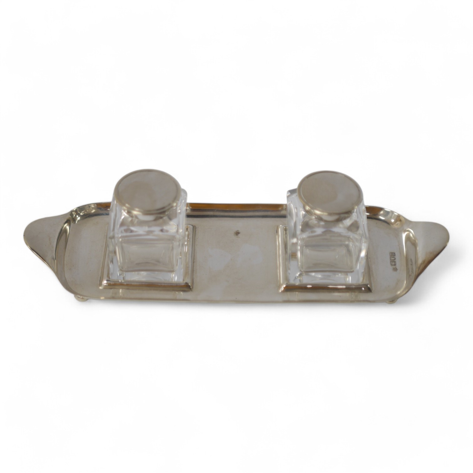 An Edwardian silver rectangular inkstand, with two silver mounted glass wells, Josiah Williams & Co, London, 1907, stand 24.2cm, 4.1oz. Condition - poor to fair